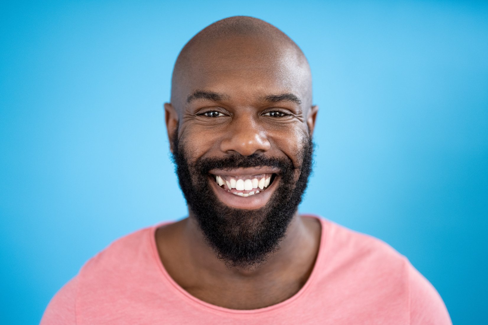 Portrait of 35 year old bearded black man grinning at camera